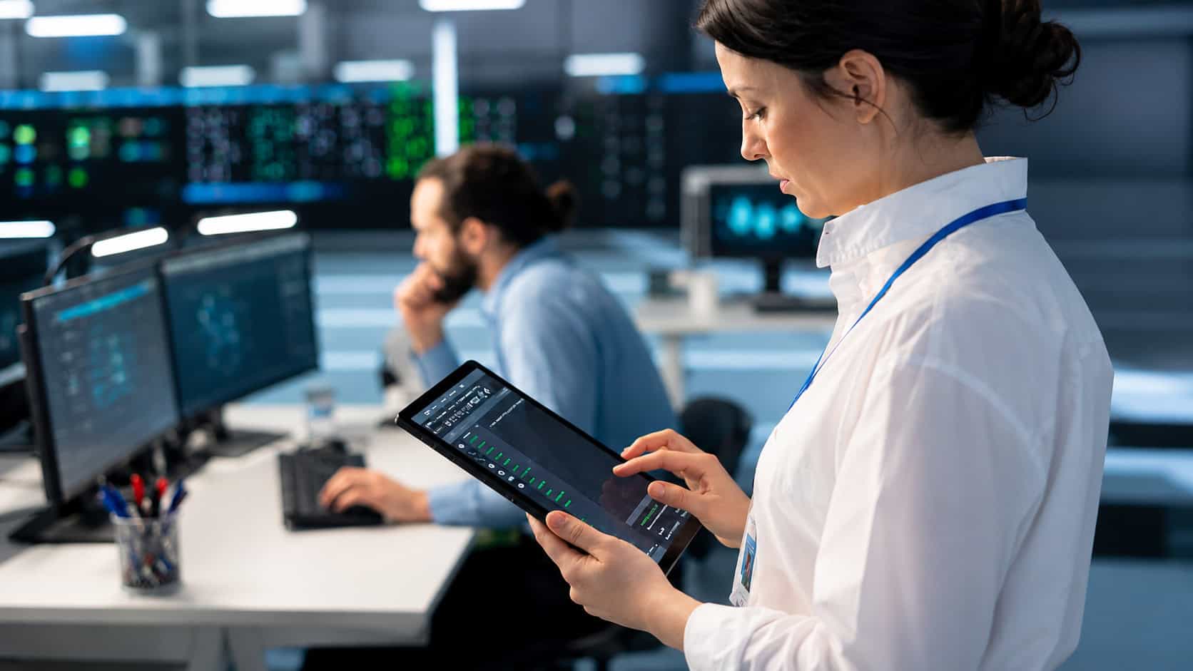 Operations personnel reviewing real-time system data and infrastructure status in a network operations center.