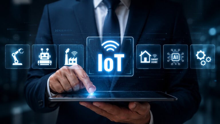 Business professional using a tablet to access a virtual IoT interface with icons for industrial robots, smart manufacturing, connected homes, artificial intelligence, and automated systems.