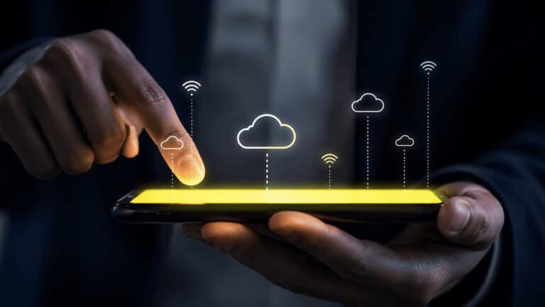 Hand interacting with a smartphone displaying cloud connectivity and wireless network icons, illustrating secure cloud-based data access and remote connectivity.