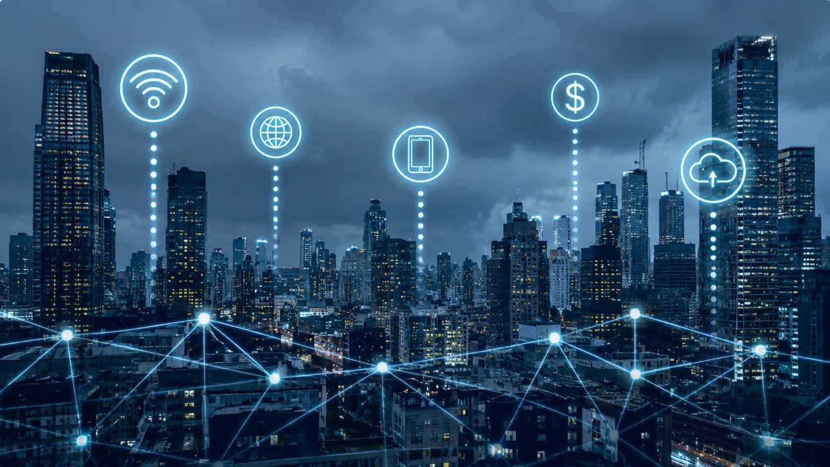 Nighttime city skyline with glowing digital network connections and smart city icons, including Wi-Fi, cloud, mobile device, and global connectivity symbols, representing urban IoT infrastructure and connected smart city technology.