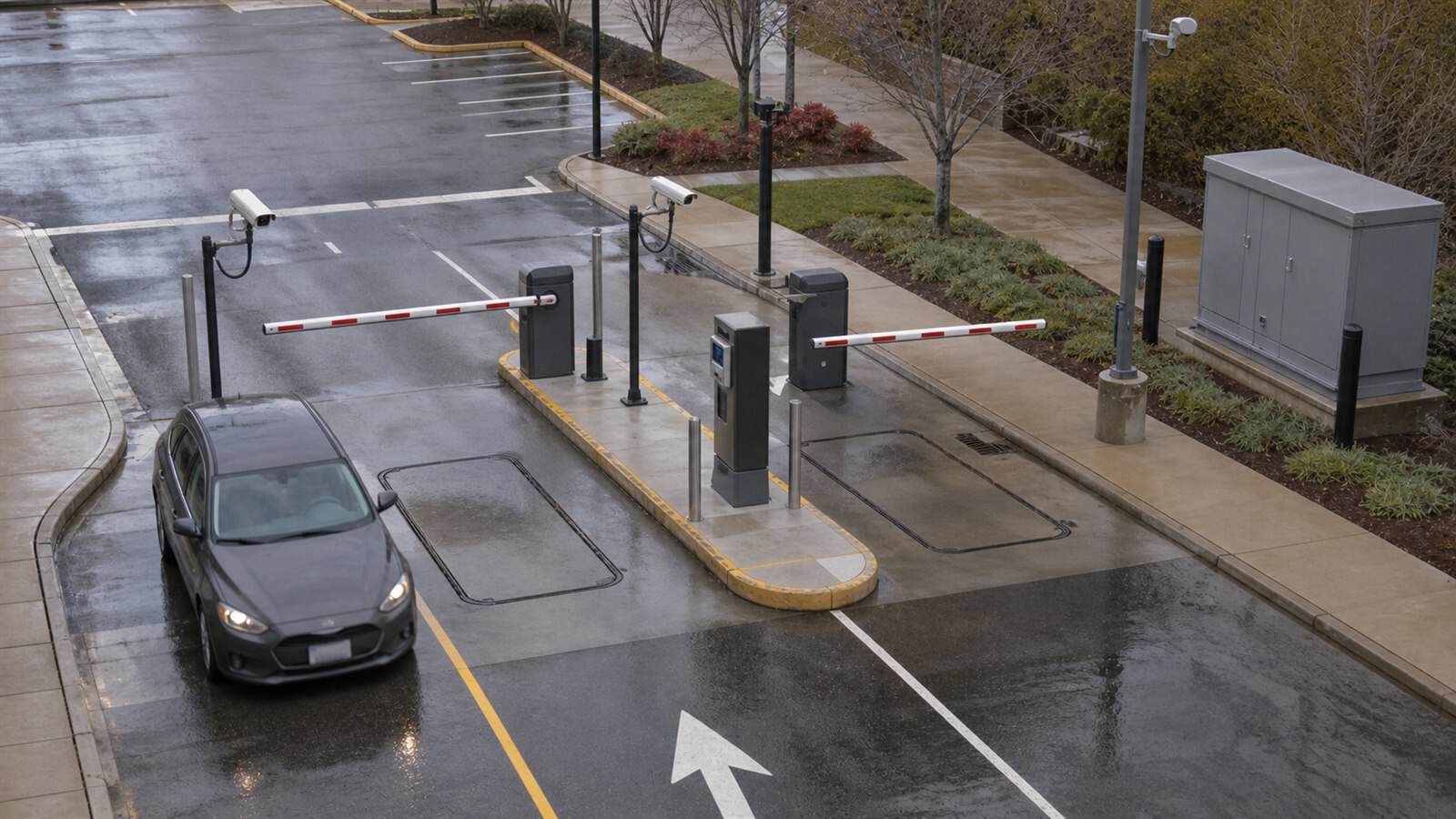 A wet smart-parking entrance uses lane cameras, barriers, pavement loops, access pedestals and a closed roadside technical enclosure.